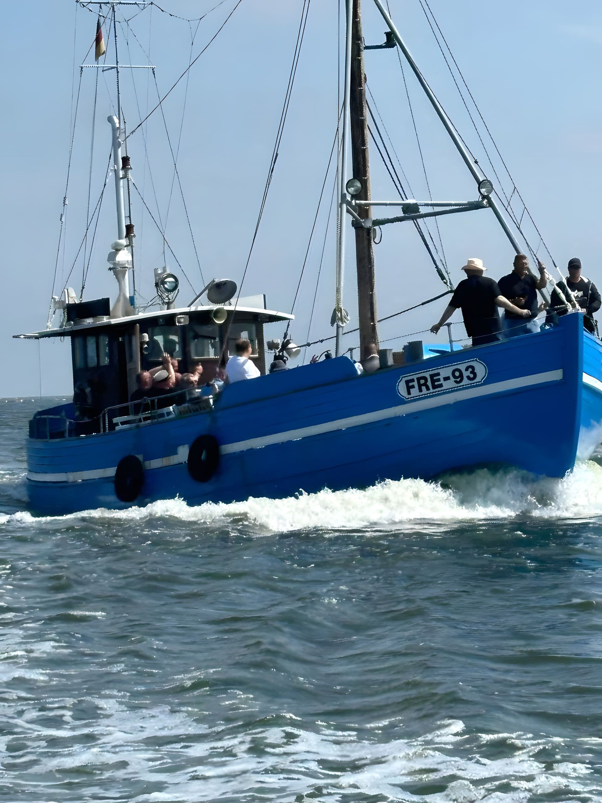 Blaues Bestattungsschiff FRE-93 mit Trauergästen auf bewegter See